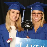 two friends taking a picture together with props